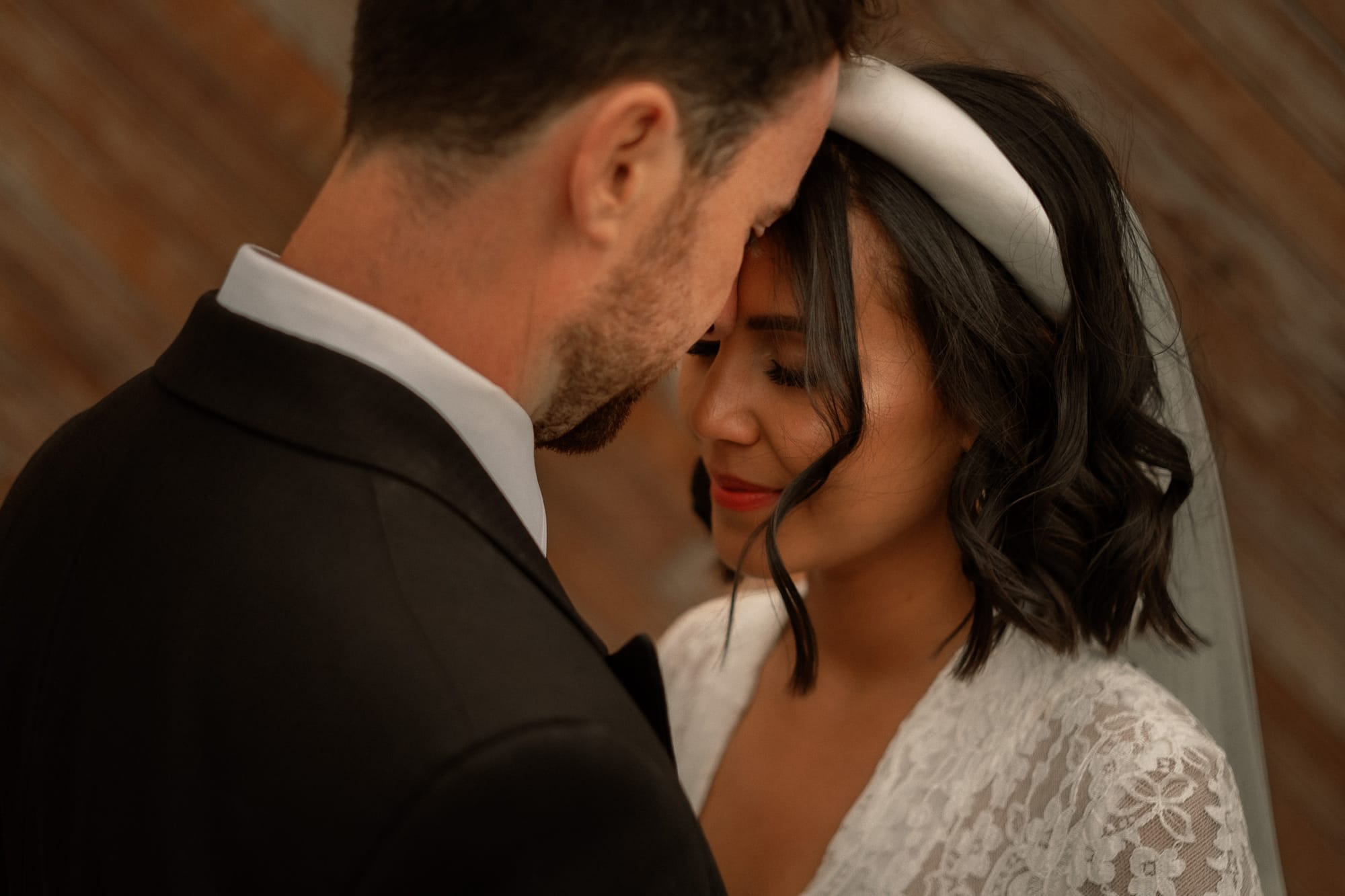 A husband kisses his wifes forehead on their wedding day