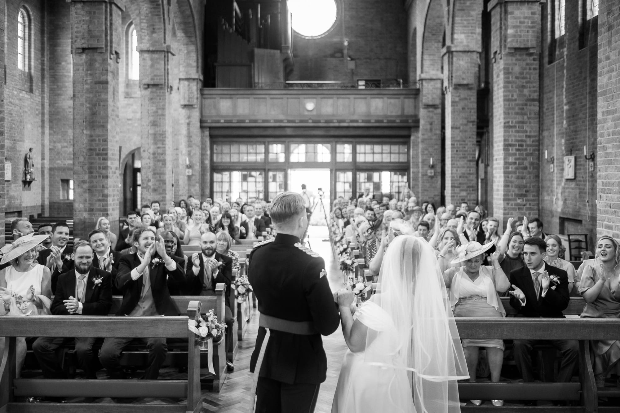 Guests cheer for newlyweds at a church in Essex