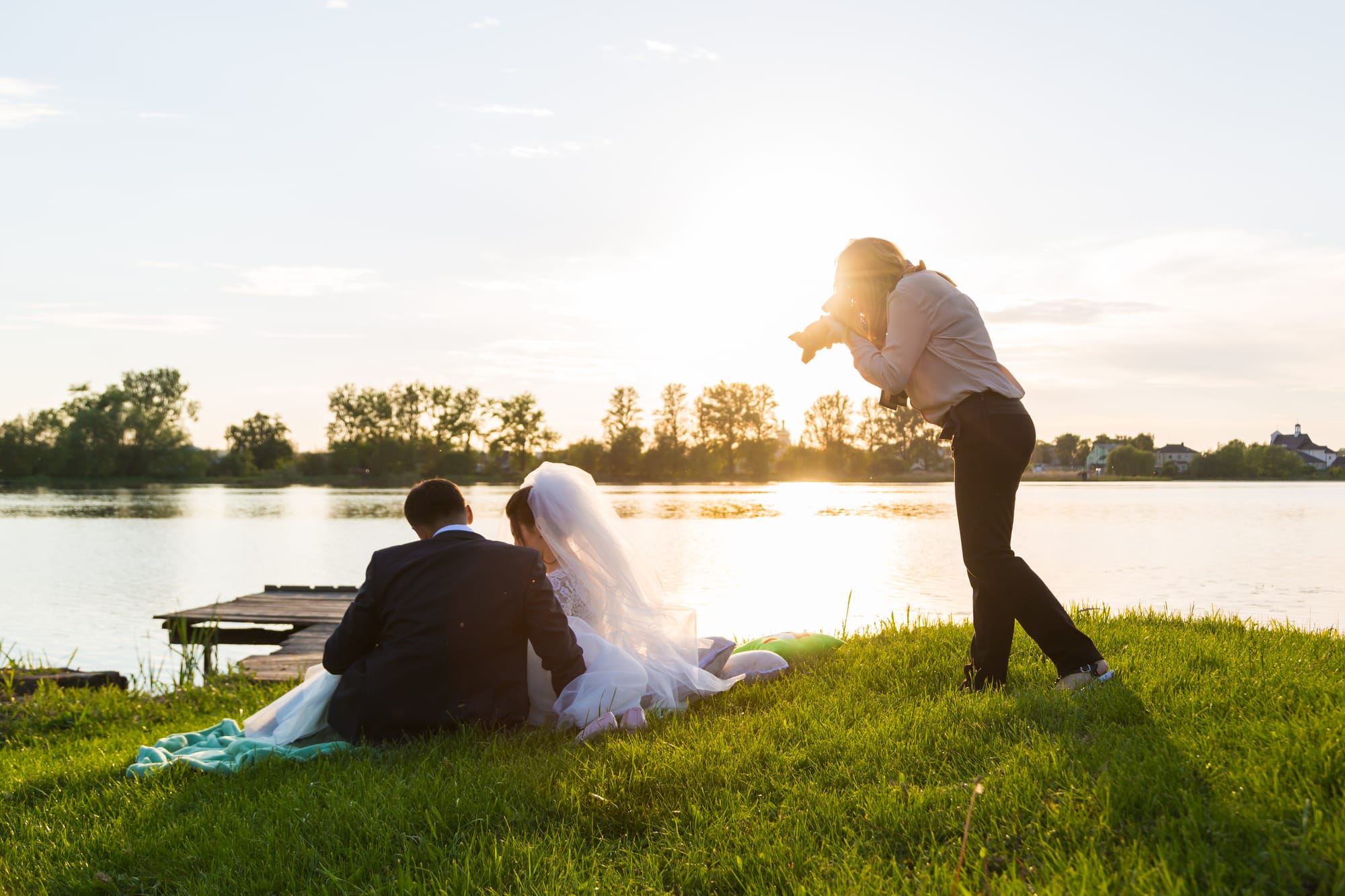 Photographer taking a photo of a couple on a sunny day